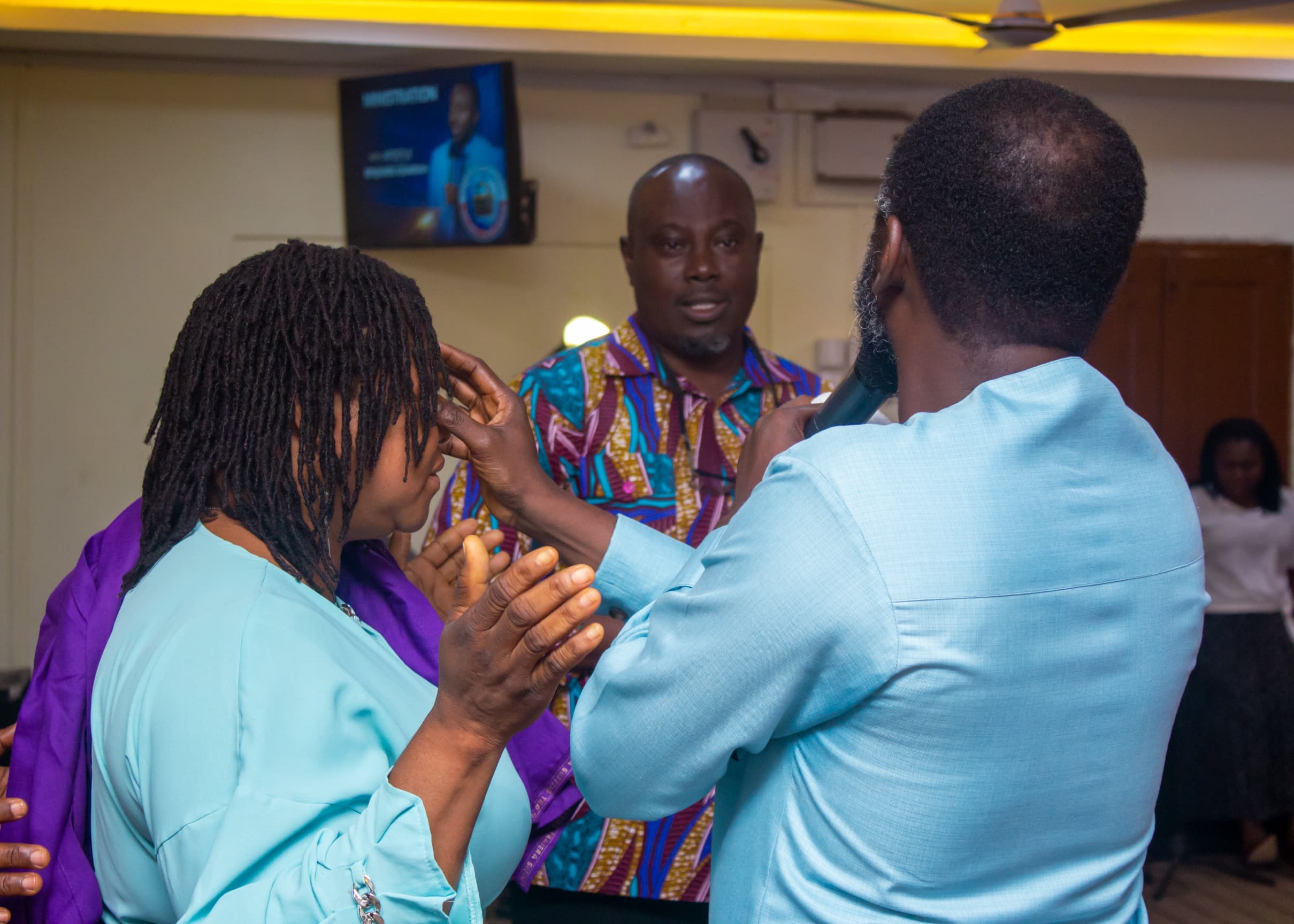 Apostle Benjamin Asamoah laying hands in prayer