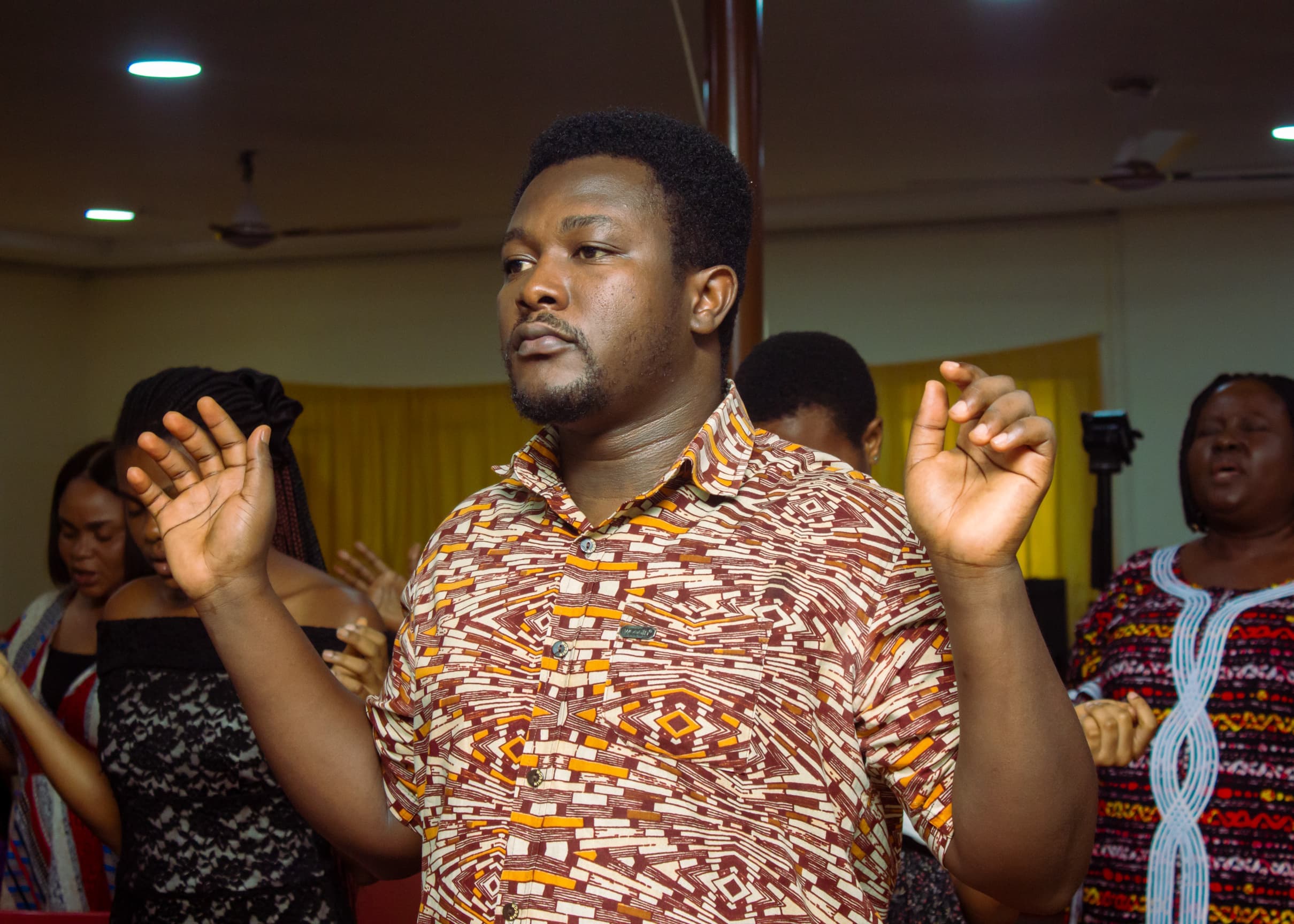 Man worshipping with raised hands at The God Realm Chapel