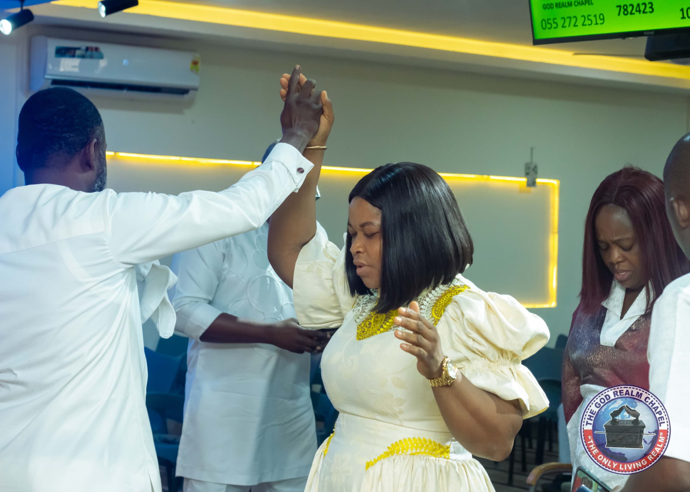 Pastor raising a congregant's hand in prayer